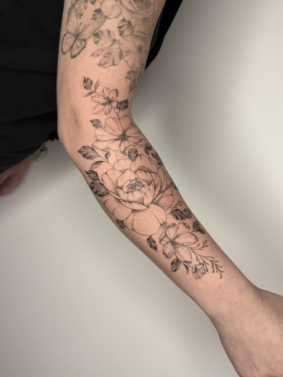 Tattoo auf dem Handgelenk mit dem Wort "CHAOS" und Pflanzen ums Handgelenk – Ink Shell aus dem Studio Rabauke Tattoo and Arts in Neu-Ulm