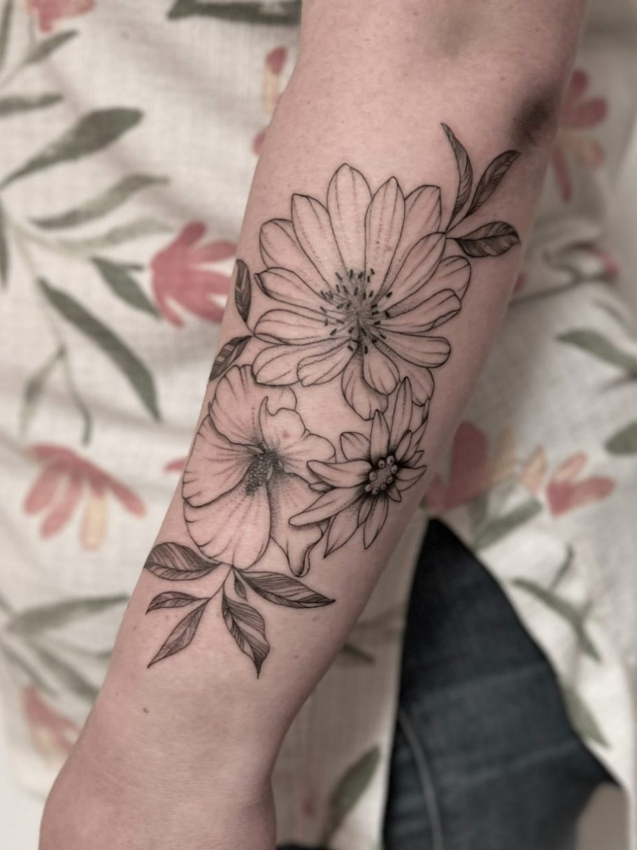 Tattoo eines floralen Designs mit Blumen und Blättern auf dem Unterarm in Fineline von Michelle Klein, Ink Shell