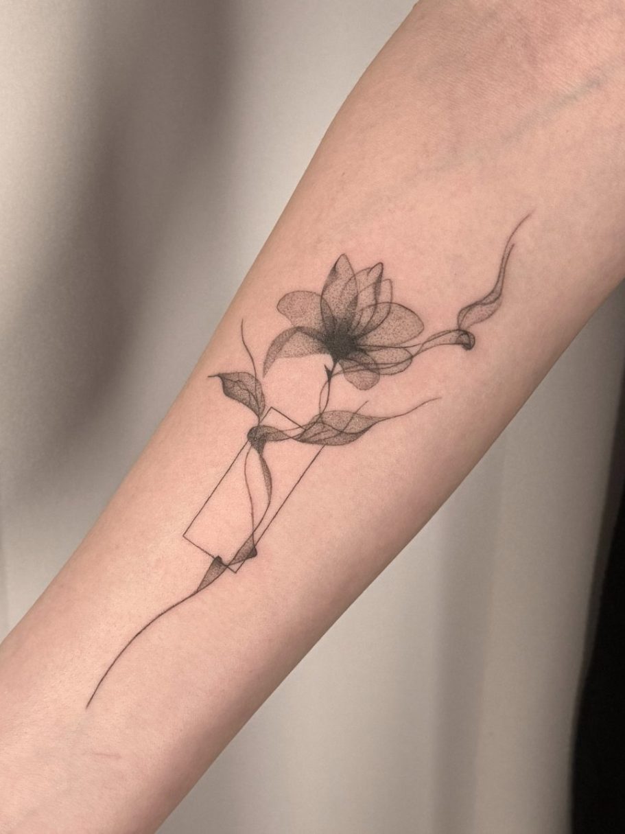 Ein filigranes Tattoo einer Blume mit geschwungener Linie in Fineline und Dotwork auf dem Unterarm – Ink Shell Tattoo