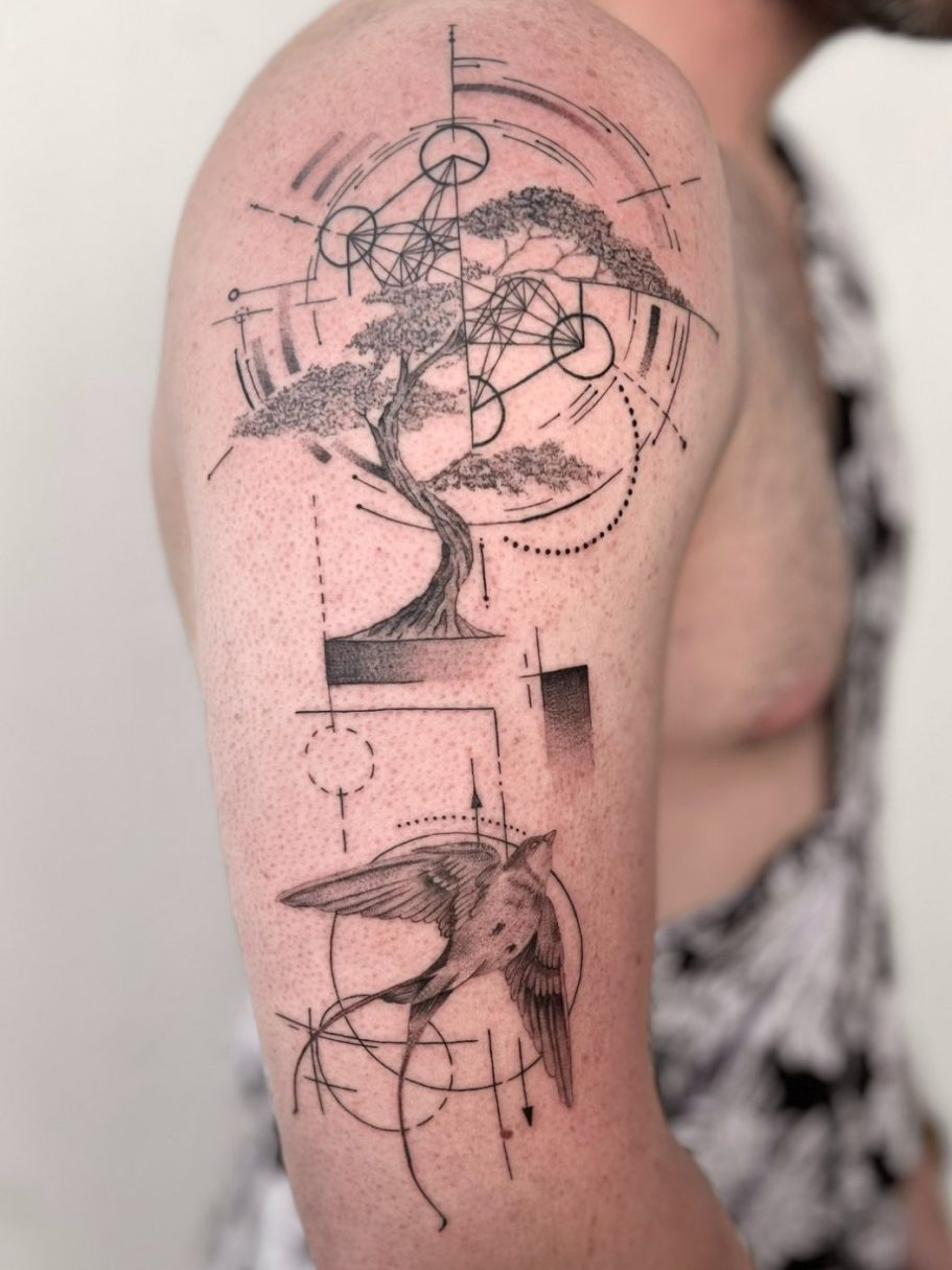 Tattoo auf dem Oberarm mit einem Baum, Vogel, geometrischen Formen und abstrakten Linien – Ink Shell Studio
